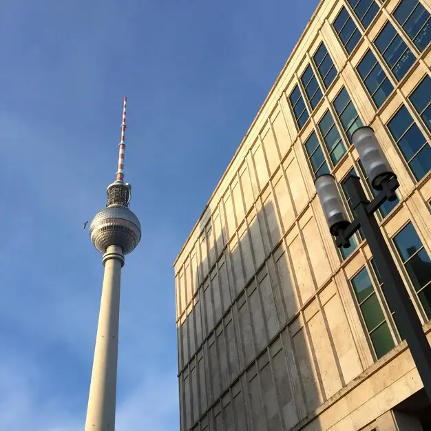 Berliner Fernsehturm am Alexanderplatz vor blauem Himmel.